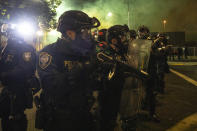 Tear gas fills the air as police take control of the streets during protests, Friday, Sept. 18, 2020, in Portland, Ore. (AP Photo/Paula Bronstein)