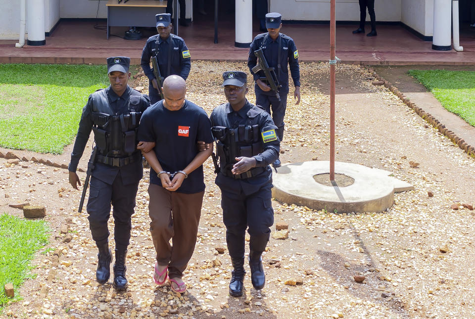 Denis Kazungu, front center, is escorted by police in Kicukiro Primary Court in Kigali, Rwanda, Thursday, Sept.21, 2023. A suspected serial killer in Rwanda on Thursday pleaded guilty at a court on Thursday, saying he killed 14 people. Most of the victims were women. Denis Kazungu, 34, admitted guilt to charges that included murder, rape and robbery. He appeared at the Kicukiro Court in the capital, Kigali, and didn't appear to show any emotion during the hearing.(AP Photo/Rashid Bugiranfura)