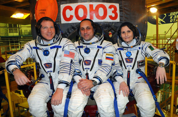 NASA astronaut Terry Virts (left), Russian cosmonaut Anton Shkaplerov and Italian astronaut Samantha Cristoforettie of the European Space Agency pose for a crew photo with their Soyuz spacecraft ahead of a Nov. 23, 2014 launch from Baikonur Cos