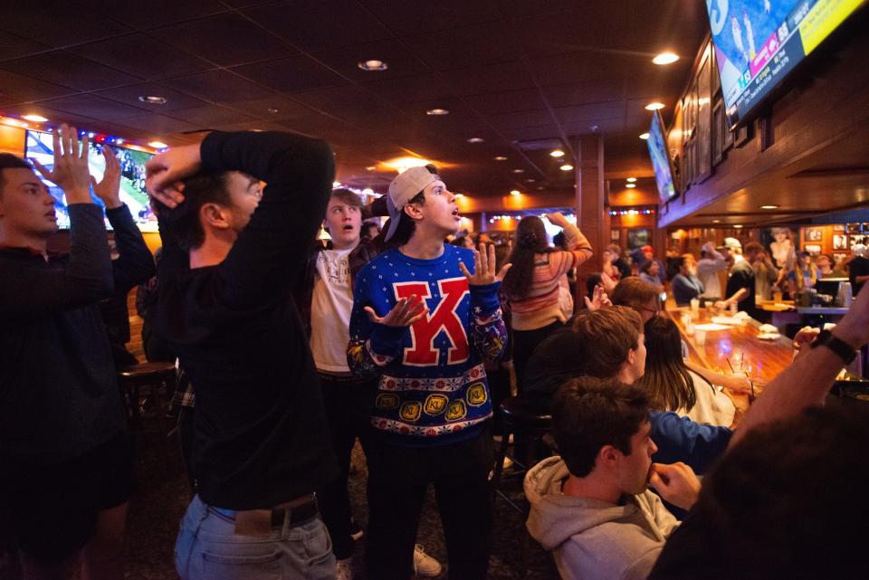 Kansas University junior Adam Lamrani, middle, reacts at Logie’s on Mass Street in Lawrence after Kansas fails to complete a two-point conversion, giving Arkansas the win in Wednesday's Liberty Bowl in Memphis. The Jayhawks lost 53-55 in the third overtime.