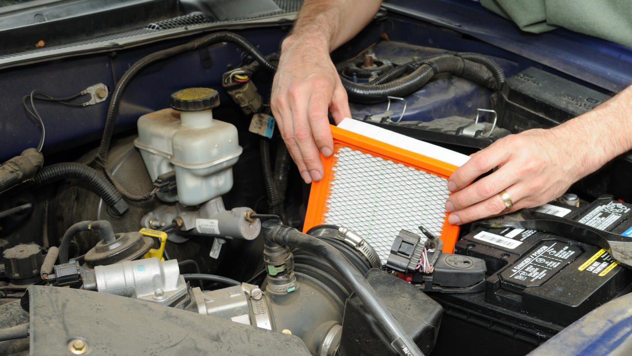 Man replacing an automotive air filter.