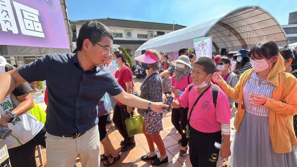 劉建國化身推銷員向民眾推銷仙草茶。（記者林金聖翻攝）