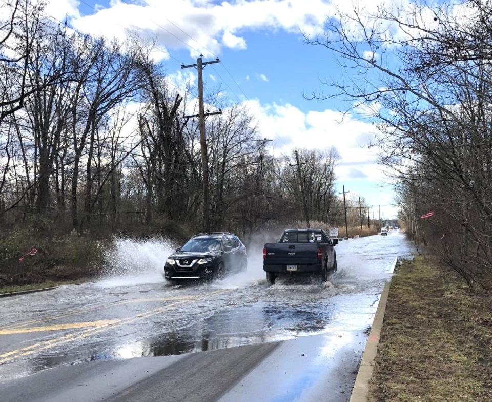 Vehicles drive through a flooded section of State Road in Bensalem Wednesday after a powerful storm with high winds drenched Bucks County Tuesday into Wednesday morning.