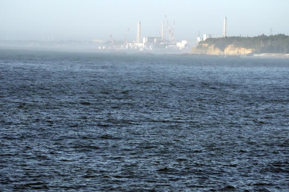 The Fukushima Daiichi nuclear power plant, damaged by a massive March 11, 2011, earthquake and tsunami, is seen from the nearby Ukedo fishing port in Namie town, northeastern Japan, Thursday, Aug. 24, 2023. The Fukushima Daiichi nuclear power plant will start releasing treated and diluted radioactive wastewater into the Pacific Ocean as early as Thursday. (AP Photo/Eugene Hoshiko)