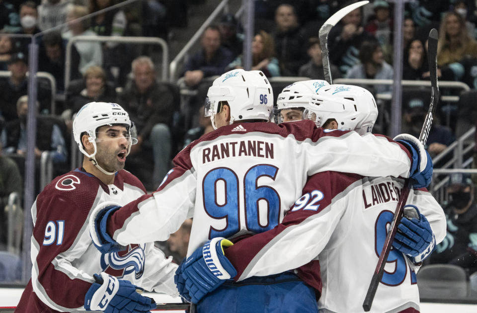 Colorado Avalanche including center Nazem Kadri (91), right wing Mikko Rantanen (96) and left wing Gabriel Landeskog (92) celebrate a power play goal by left wing Andre Burakovsky (not shown) during the first period of an NHL hockey game against the Seattle Kraken, Friday, Nov. 19, 2021, in Seattle. (AP Photo/Stephen Brashear)