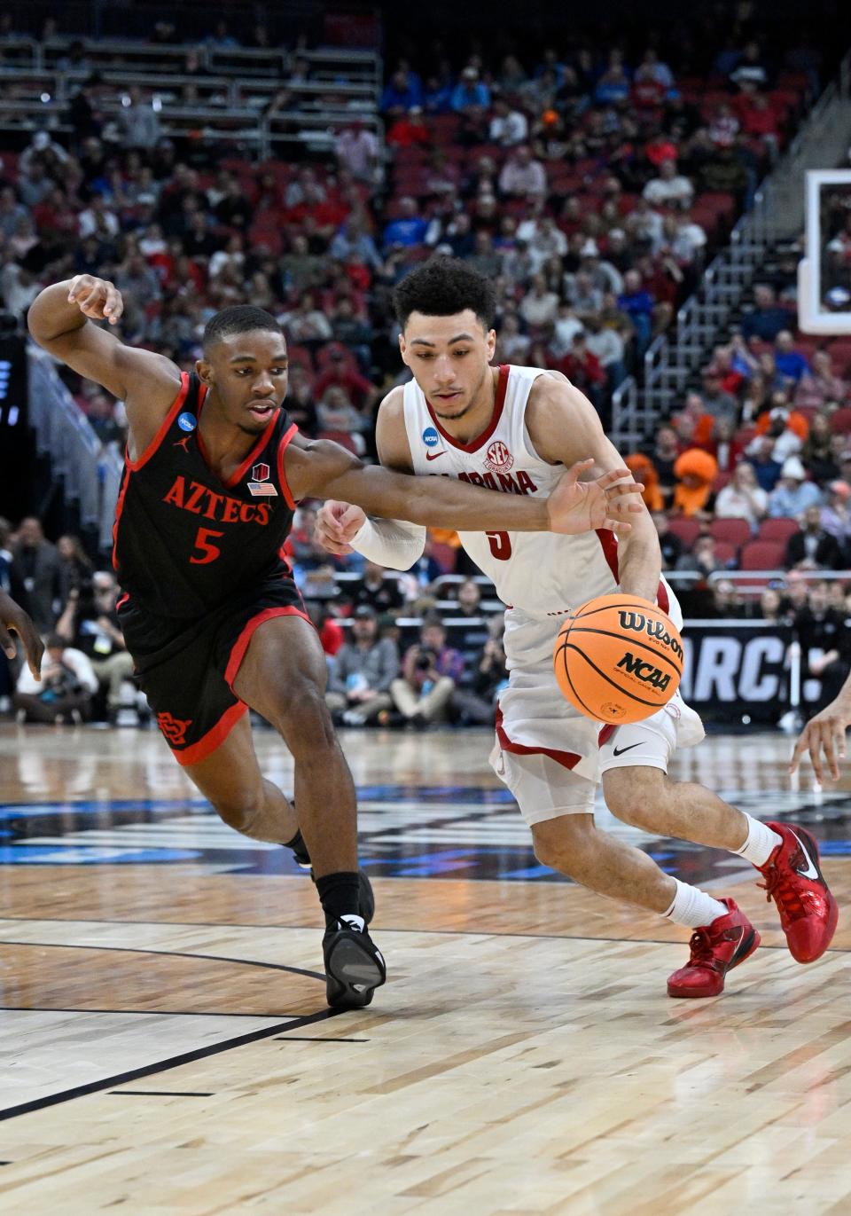 Mar 24, 2023; Louisville, KY, USA; Alabama Crimson Tide guard Jahvon Quinerly (5) drives against San Diego State Aztecs guard Lamont Butler (5) during the second half of the NCAA tournament round of sixteen at KFC YUM! Center. Mandatory Credit: Jamie Rhodes-USA TODAY Sports