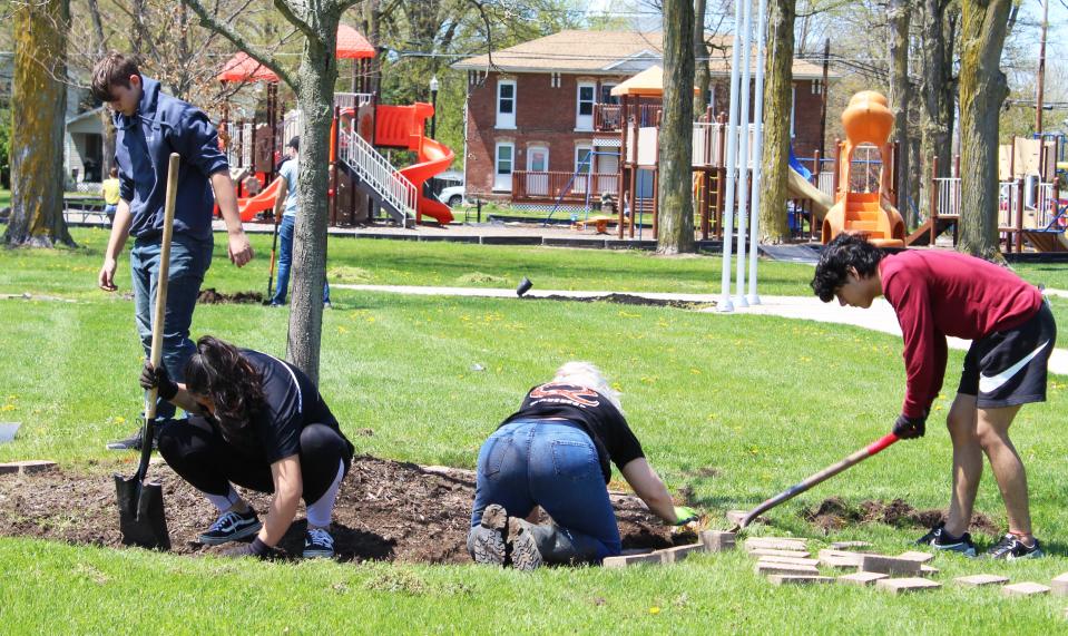 At Quincy Village Park, crews of students removed sod from around young trees, preparing for the busy summer season of destination events.