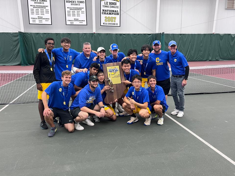 Carmel boys tennis team poses with the IHSAA team championship trophy after beating Columbus North at DePauw University on Saturday, Oct. 14, 2023.