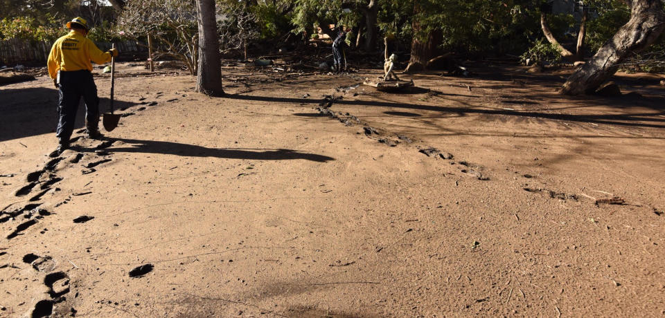 <p>Santa Barbara County Fire Engineer Rick Pinal navigates through a muddy Montecito, Calif., home backyard on Jan. 13, 2018. The home was destroyed by deadly mudflow and debris early Tuesday morning following heavy rainfall. (Mike Eliason/Santa Barbara County Fire Department via AP) </p>