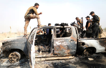 Iraqi special forces soldiers looks at a destroyed Islamic State vehicle in a village near Mosul, Iraq October 25, 2016. REUTERS/Goran Tomasevic