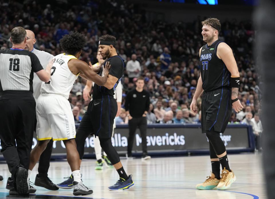 Dallas Mavericks guard Luka Doncic (77) looks on as teammate guard Seth Curry, center, tangles with Utah Jazz guard Collin Sexton (2) during the second half of an NBA basketball game in Dallas, Wednesday, Dec. 6, 2023. (AP Photo/LM Otero)