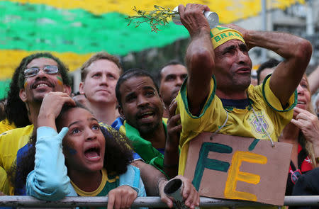Fans react as they watch the broadcast of the FIFA World Cup Group E soccer match between Brazil and Switzerland, in Rio de Janeiro, Brazil June 17, 2018. The sign reads: "Faith." REUTERS/Sergio Moraes