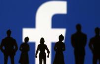 FILE PHOTO: Small toy figures are seen in front of Facebook logo in this illustration picture