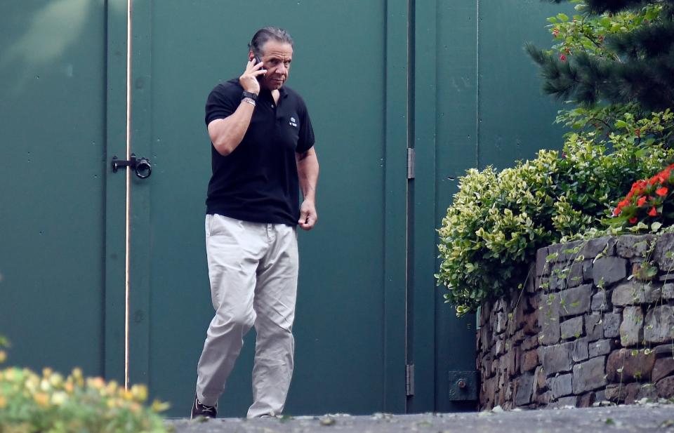 Gov. Andrew Cuomo talks on the phone while walking with his dog Captain at the New York state Executive Mansion, Saturday, Aug. 7, 2021, in Albany, N.Y. An investigation found that Cuomo sexually harassed multiple women in and out of state government.