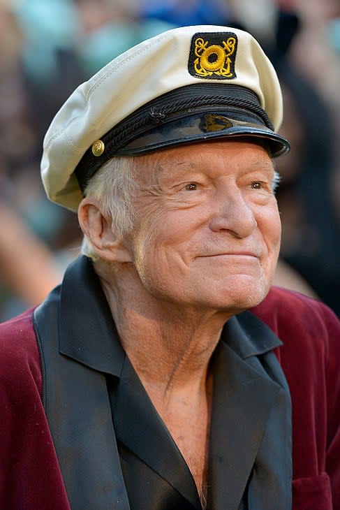 Elderly man wearing a captain's hat and a velvet robe at an event