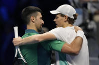 Italy's Jannik Sinner, right, embraces Serbia's Novak Djokovic at the end of the singles tennis match of the ATP World Tour Finals at the Pala Alpitour, in Turin, Italy, Tuesday, Nov. 14, 2023. (AP Photo/Antonio Calanni)