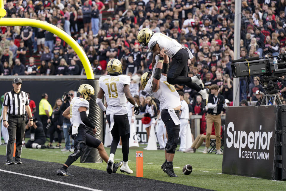 Central Florida running back RJ Harvey, upper right, celebrates with teammates after scoring during the first half of an NCAA college football game against Cincinnati, Saturday, Nov. 4, 2023, in Cincinnati. (AP Photo/Jeff Dean)