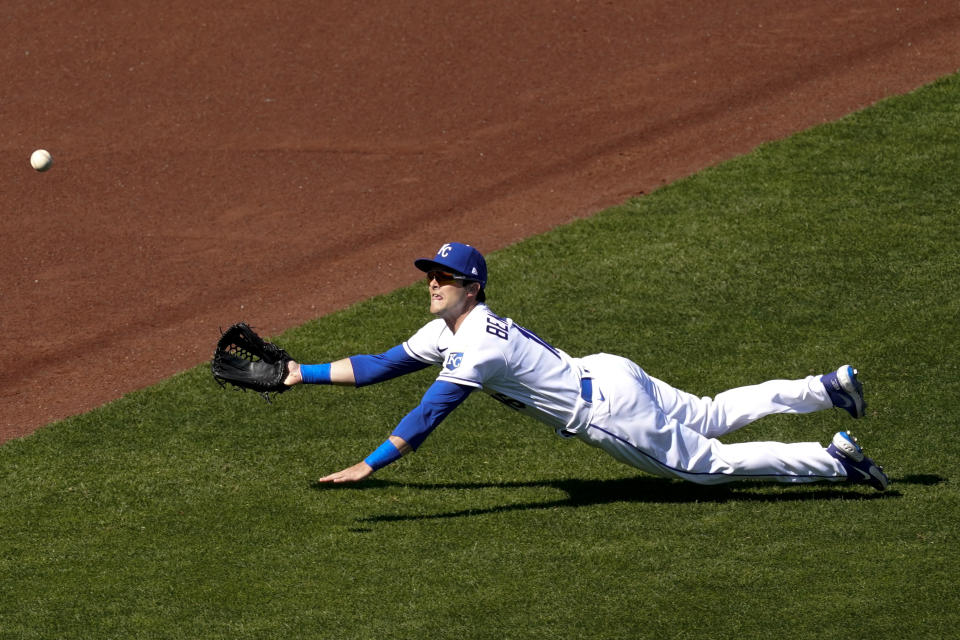 Kansas City Royals' Andrew Benintendi dives for but misses a three-run double hit by Texas Rangers' Nate Lowe during the first inning of a baseball game Thursday, April 1, 2021, in Kansas City, Mo. (AP Photo/Charlie Riedel)