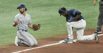 Texas Rangers' Charlie Culberson, left, looks to the Texas dugout after Tampa Bay Rays' Manuel Margot, right, stole third base during the fourth inning of a baseball game Thursday, April 15, 2021, in St. Petersburg, Fla. (AP Photo/Steve Nesius)