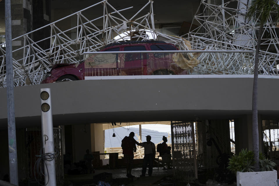 A damaged car is covered by debris in the driveway of a hotel after Hurricane Otis ripped through Acapulco, Mexico, Thursday, Oct. 26, 2023. The hurricane that strengthened swiftly before slamming into the coast early Wednesday as a Category 5 storm has killed at least 27 people as it devastated Mexico’s resort city of Acapulco. (AP Photo/Felix Marquez)