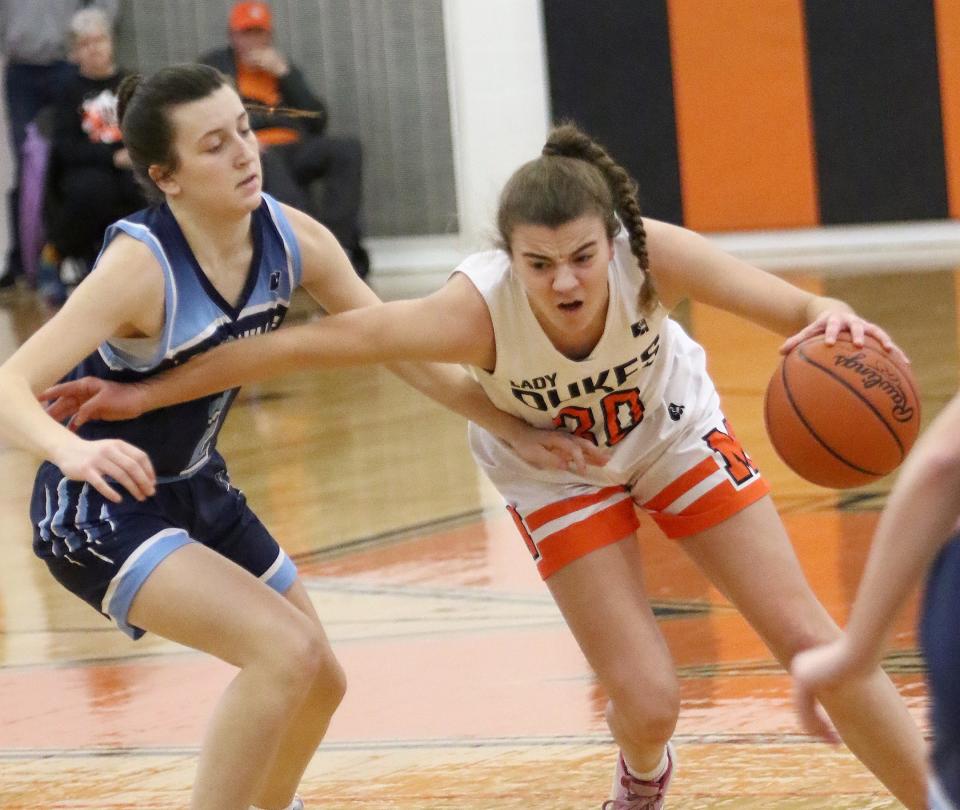 Marlington's Elizabeth Mason, right, drives to the hoop past Louisville's Courtney Barwick during action Saturday afternoon at Marlington High School, January 28, 2023.