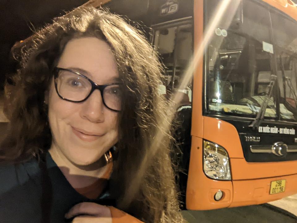 Hannah Shewan Stevens smiling for selfie in front of bus in Laos