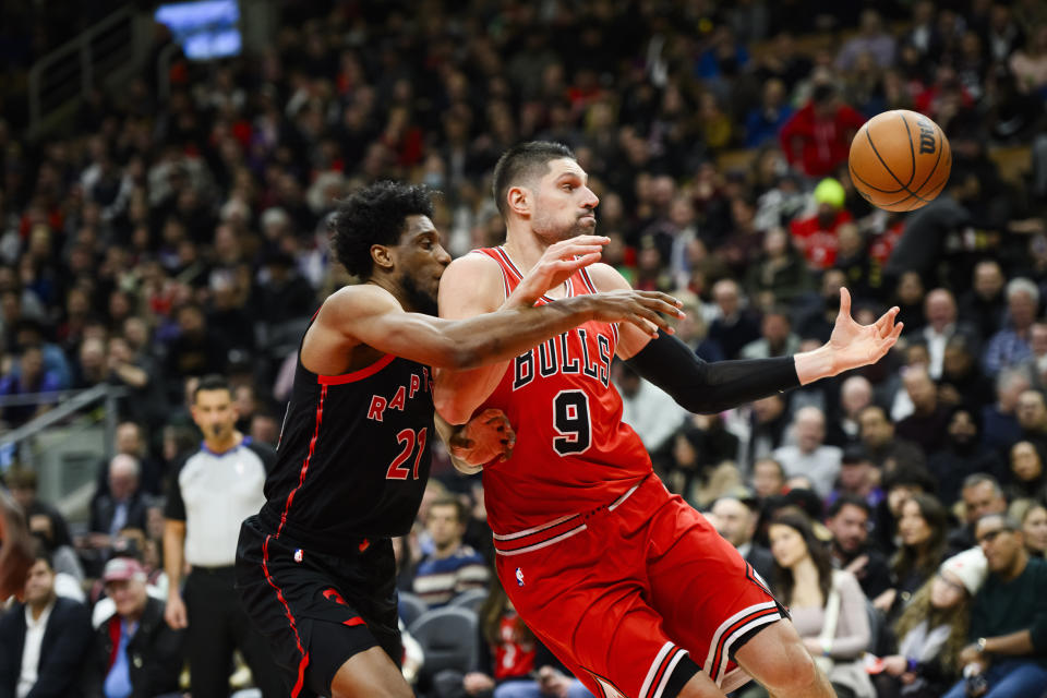 Chicago Bulls center Nikola Vucevic (9) catches the ball while guarded by Toronto Raptors forward Thaddeus Young (21) during first-half NBA basketball game action in Toronto, Thursday, Jan. 18, 2024. (Christopher Katsarov/The Canadian Press via AP)