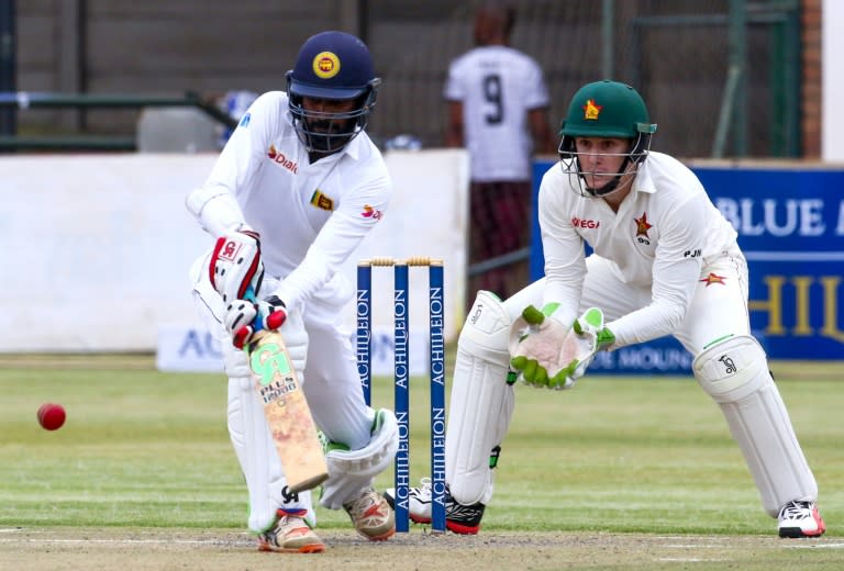 Sri Lanka batsman Upul Tharanga (L) plays a shot as Zimbabwe's wicketkeeper Peter Moor looks on during the second day's play in the first Test at the Harare Sports Club, on October 30, 2016