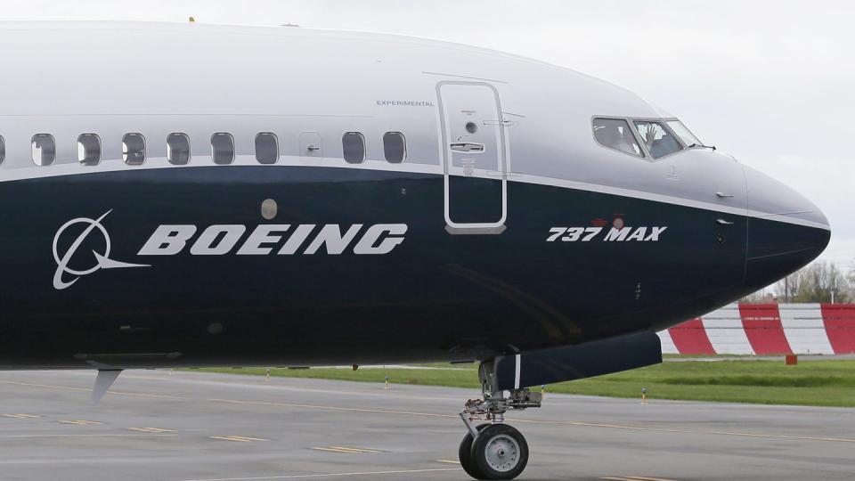 Ein Pilot winkt aus der Pilotenkabine eines Flugzeuges vom Typ Boeing 737 MAX auf dem Flughafen.