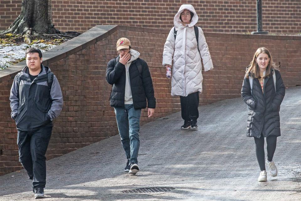 Bundled-up University of Delaware students exit Smith Hall after the early morning snow ceased falling in Newark, Tuesday, Feb. 13, 2024.