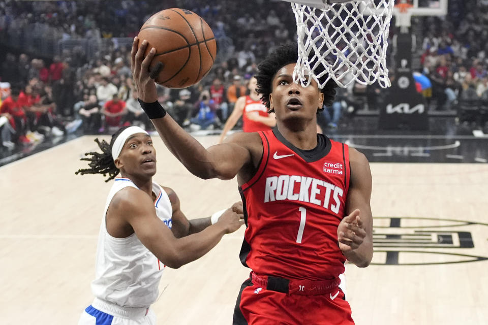 Houston Rockets forward Amen Thompson, right, shoots as Los Angeles Clippers guard Terance Mann defends during the first half of an NBA basketball game Sunday, April 14, 2024, in Los Angeles. (AP Photo/Mark J. Terrill)