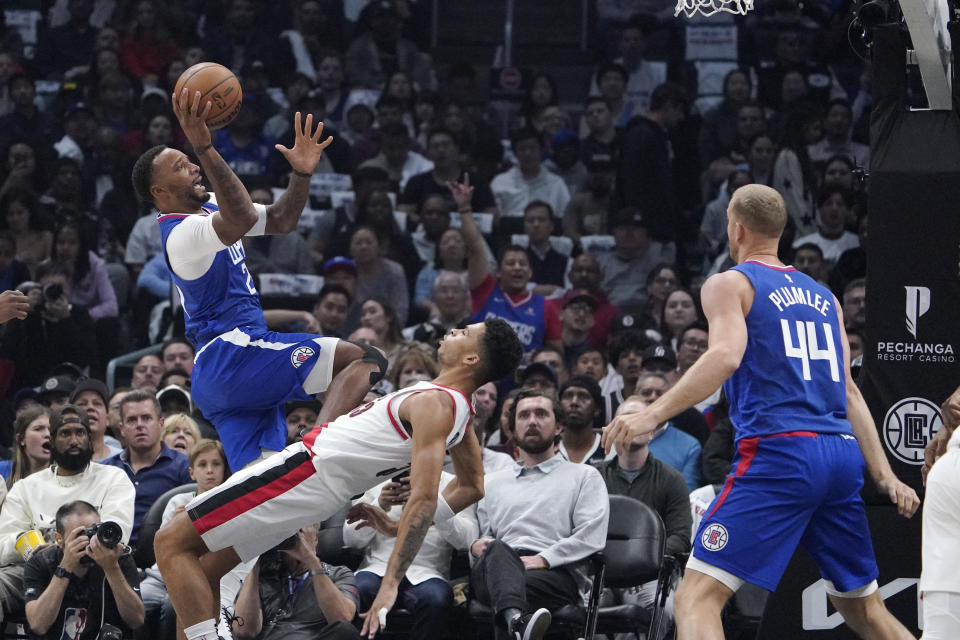 Los Angeles Clippers guard Norman Powell, left, shoots as Portland Trail Blazers forward Toumani Camara, center, defends and center Mason Plumlee watches during the first half of an NBA basketball game Wednesday, Oct. 25, 2023, in Los Angeles. (AP Photo/Mark J. Terrill)