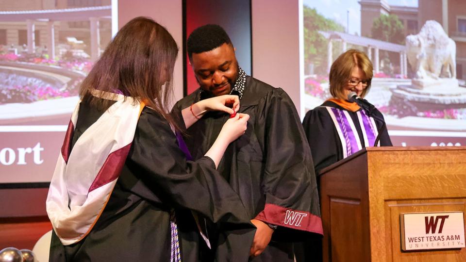 Azra Barakovic, instructor of nursing, pins nursing graduate Kiven Peter Nsameluh during a Dec. 8 ceremony.