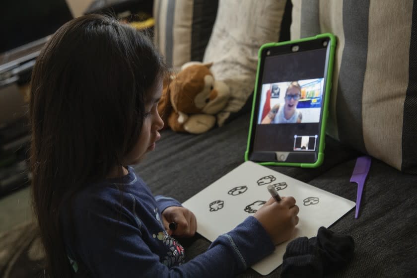 ORANGE, CA-APRIL 28, 2020: Paola Perez, 5, a TK student at TLC Charter, an elementary school in Orange, draws clouds, when asked by her teacher, Leslie James, seen on computer, to visually describe the weather outside, during a zoom class. Perez was photographed at her home in Orange. (Mel Melcon/Los Angeles Times)