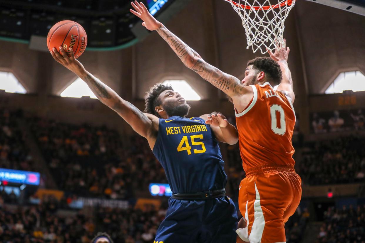 West Virginia guard Seth Wilson (45) shoots against Texas forward Timmy Allen during the second half at WVU Coliseum, Feb. 26, 2022