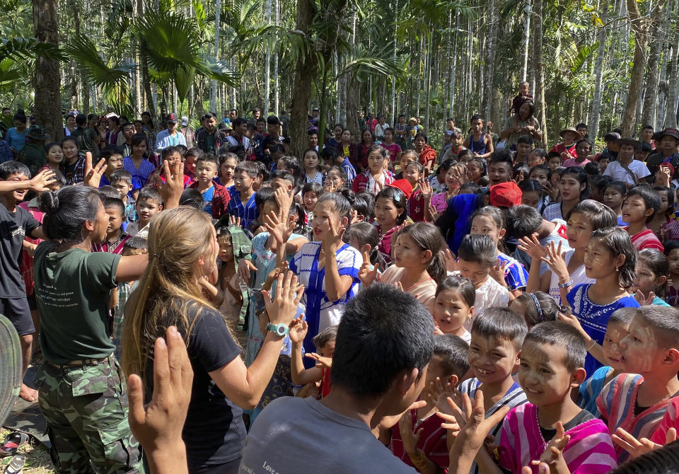 In this photo released by the Free Burma Rangers, members of the humanitarian group Free Burma Rangers sing songs with ethnic Karen children who are living in the jungle to escape an ongoing local offensive by the Myanmar army, in northern Karen State on Jan. 13, 2021. Aid organizations say more than 8,000 villagers have fled their homes after they came under mortar fire from the military. (Free Burma Rangers via AP)