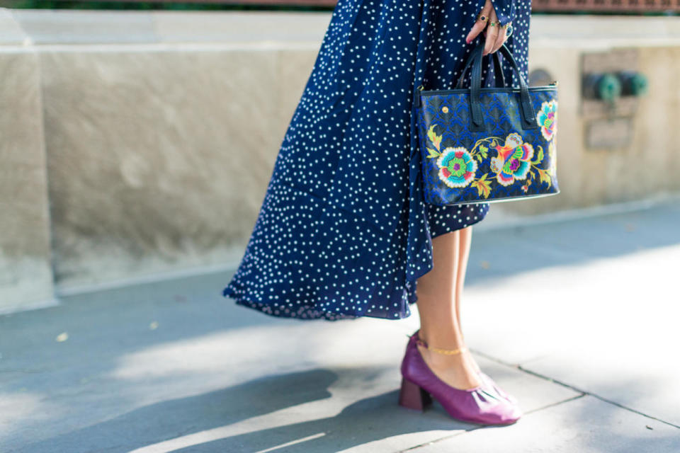 A feminine floral tote looks lovely with a flowing maxidress and the love-’em-or-hate-’em “glove shoe” (we love ’em), at New York Fashion Week.