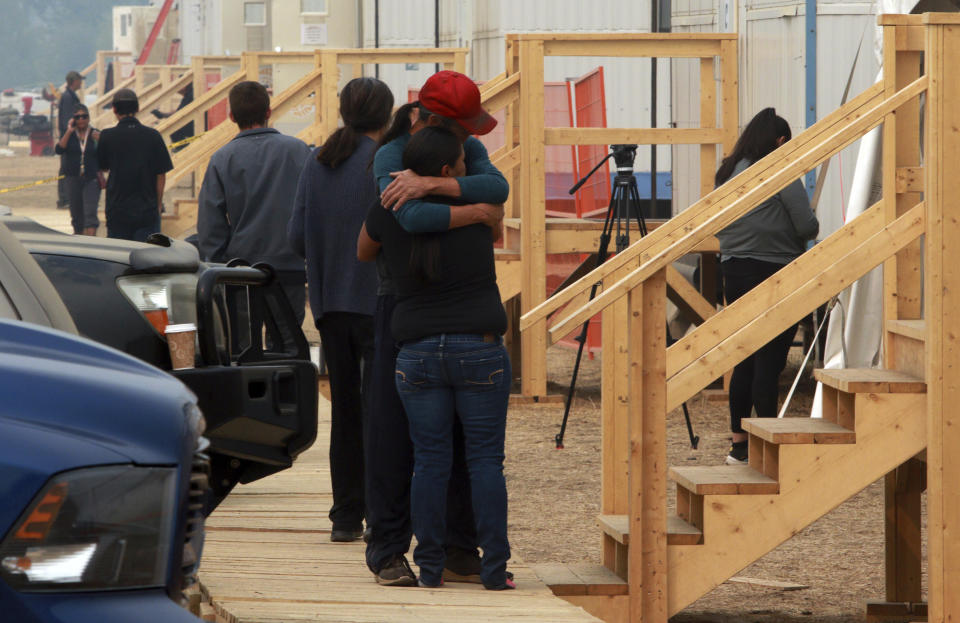 People hug at the Tselletkwe Lodge, a place for Indigenous evacuees and others who have been displaced due to wildfires, in Kamloops, British Columbia, Tuesday, Aug. 22, 2023. (Chad Hipolito/The Canadian Press via AP)