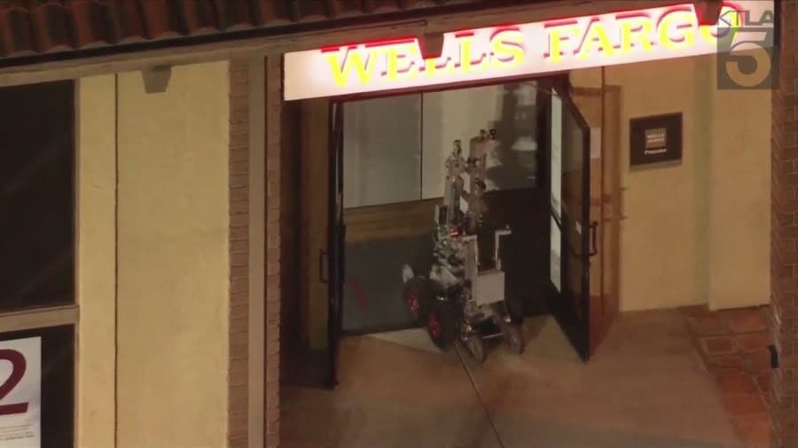 A remote-controlled robot enters to inspect a Wells Fargo bank after a bomb threat on March 26, 2024. (KTLA)
