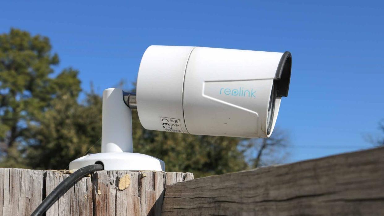  A Reolink PoE security camera on top of a fence. 