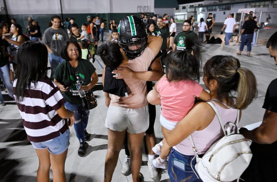 A crowd of family, friends and supporters gathers to hug Reedley’s Malachi Rios after the game against Roosevelt Friday night, Aug. 25, 2023 in Reedley. Rios is going back to chemotherapy after the game.