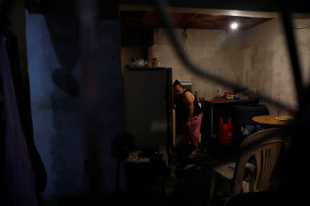 Minerva Savago, 58, mops the floor with the little water she collected during the day, on the ground floor of an apartment block in downtown in Caracas, Venezuela, March 19, 2019. REUTERS/Carlos Jasso