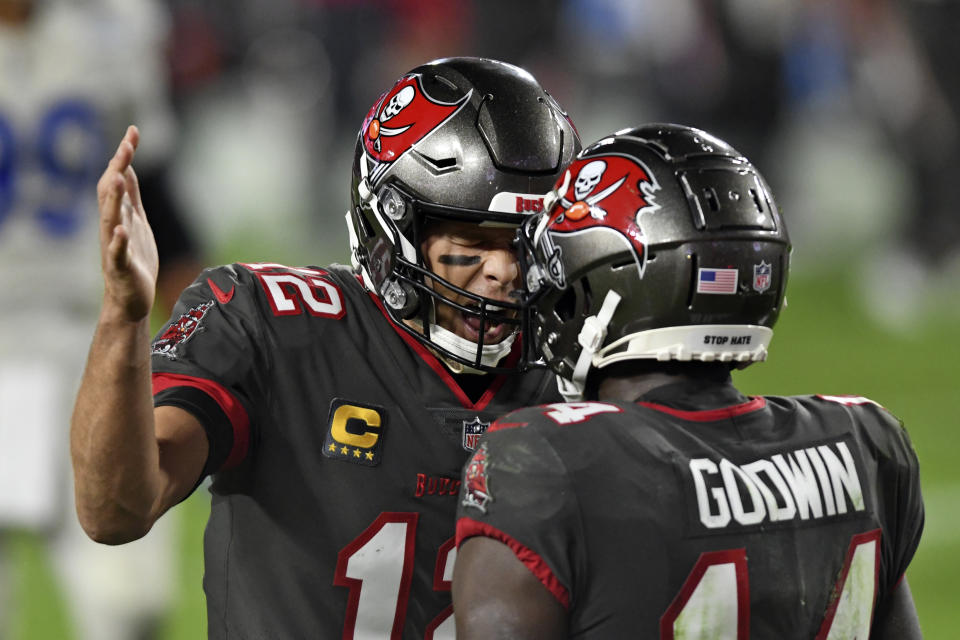 Tampa Bay Buccaneers quarterback Tom Brady (12) celebrates with wide receiver Chris Godwin (14) after Godwin caught a touchdown pass during the second half of an NFL football game against the Los Angeles Rams Monday, Nov. 23, 2020, in Tampa, Fla. (AP Photo/Jason Behnken)