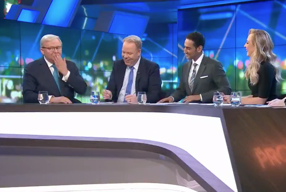 Former Australian prime minister Kevin Rudd puts his hand to his mouth after swearing on the Project as co-hosts laugh.