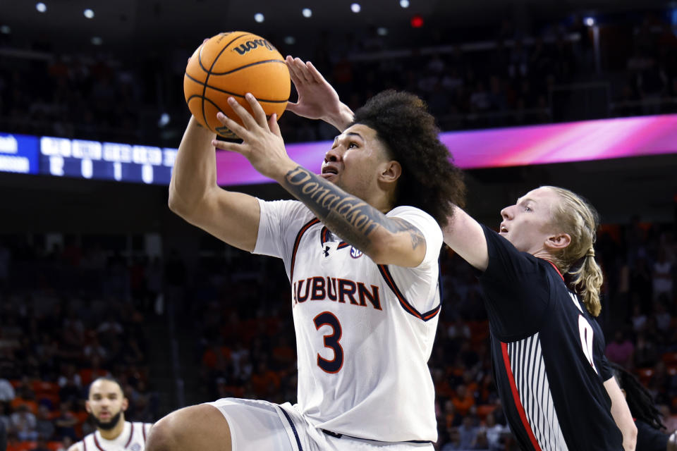 Auburn guard Tre Donaldson (3) goes to the basket as Georgia guard Blue Cain (0) defends during the second half of an NCAA college basketball game Saturday, March 9, 2024, in Auburn, Ala. (AP Photo/ Butch Dill)