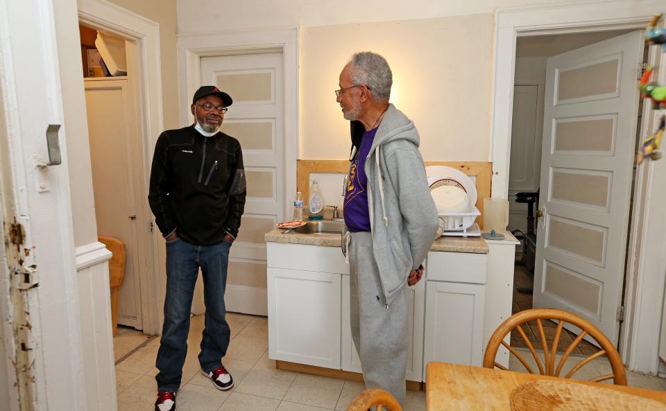 Anthony Washington, left, talks with William Harrell, property manager and executive secretary for Table of the Saints. Washington lives at The Family House, a residence for former inmates run by the organization.
