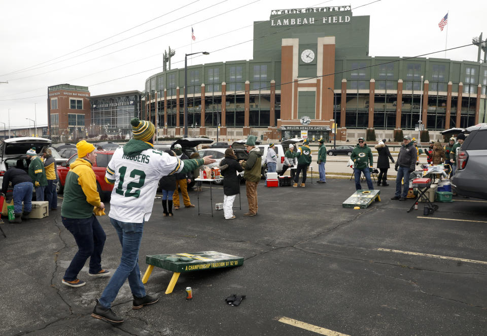 Fans toss bean bags outside of Lambeau Field before an NFL divisional playoff football game between the Los Angeles Rams and Green Bay Packers, Saturday, Jan. 16, 2021, in Green Bay, Wis. (AP Photo/Mike Roemer)