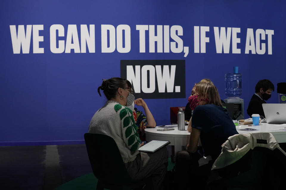 FILE - People talk in the Action Zone at the COP26 U.N. Climate Summit, in Glasgow, Scotland, Thursday, Nov. 4, 2021. The U.N. climate summit in Glasgow gathers leaders from around the world, in Scotland's biggest city, to lay out their vision for addressing the common challenge of global warming. (AP Photo/Alberto Pezzali, File)