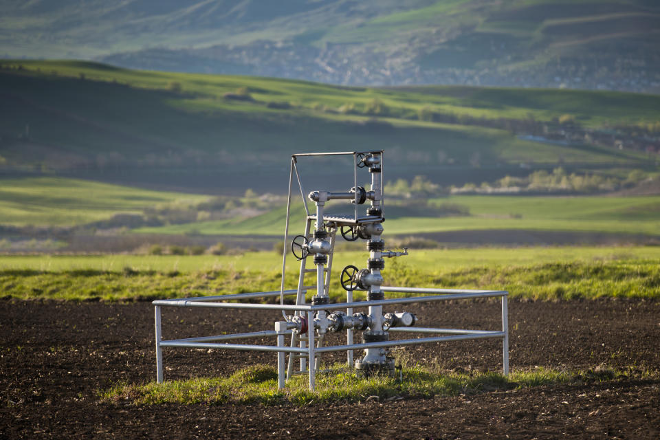 A natural gas wellhead in the middle of a field