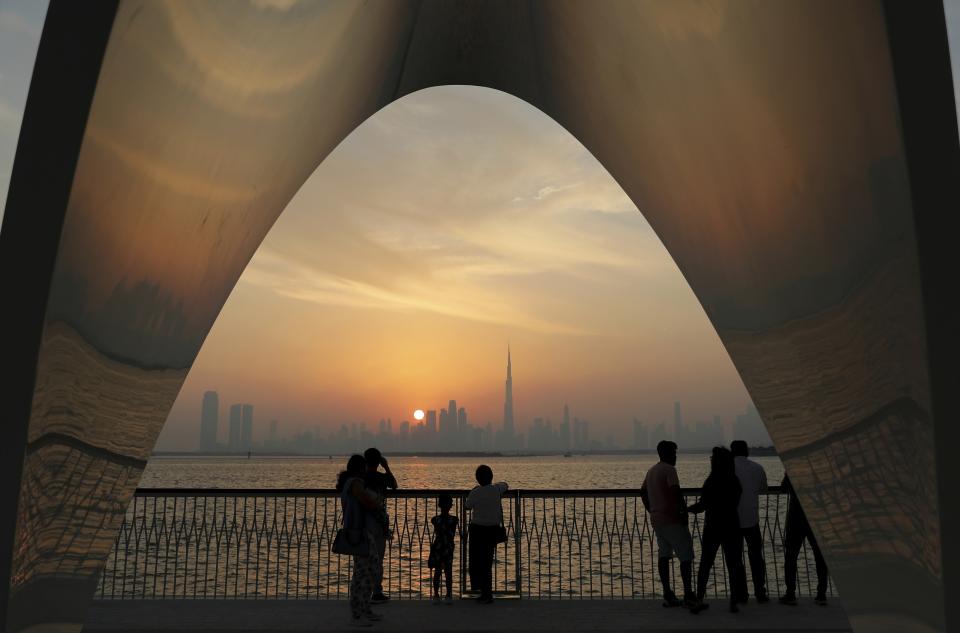 FILE- In this Friday, Oct. 18, 2019 file photo, people enjoy a city skyline view with the World's tallest building Burj Khalifa, in Dubai, United Arab Emirates. In an unmarked villa, nestled amid homes in an upscale Dubai neighborhood, sits the first fully functioning synagogue in the Arabian Peninsula in decades. Though its members keep its precise location secret, the synagogue’s existence and the tacit approval it has received from this Islamic sheikhdom represents a slow rebirth of a burgeoning Jewish community in the Persian Gulf uprooted over the decades after the creation of Israel. (AP Photo/Kamran Jebreili, File)